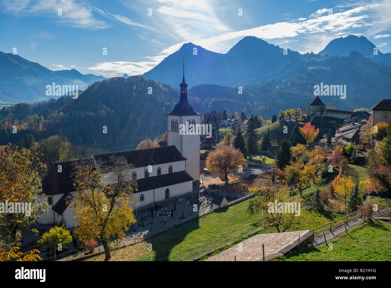 Vista della retroilluminazione con luce di autunno sulle alpi, chiesa e cimitero di Gruyeres, Svizzera Foto Stock