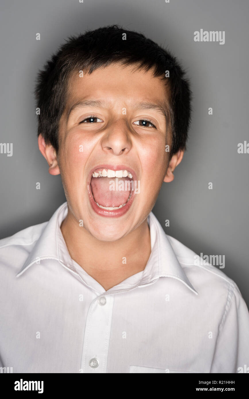 Ragazzo , 11 anni cantando loud- testa e la spalla studio shot Foto Stock