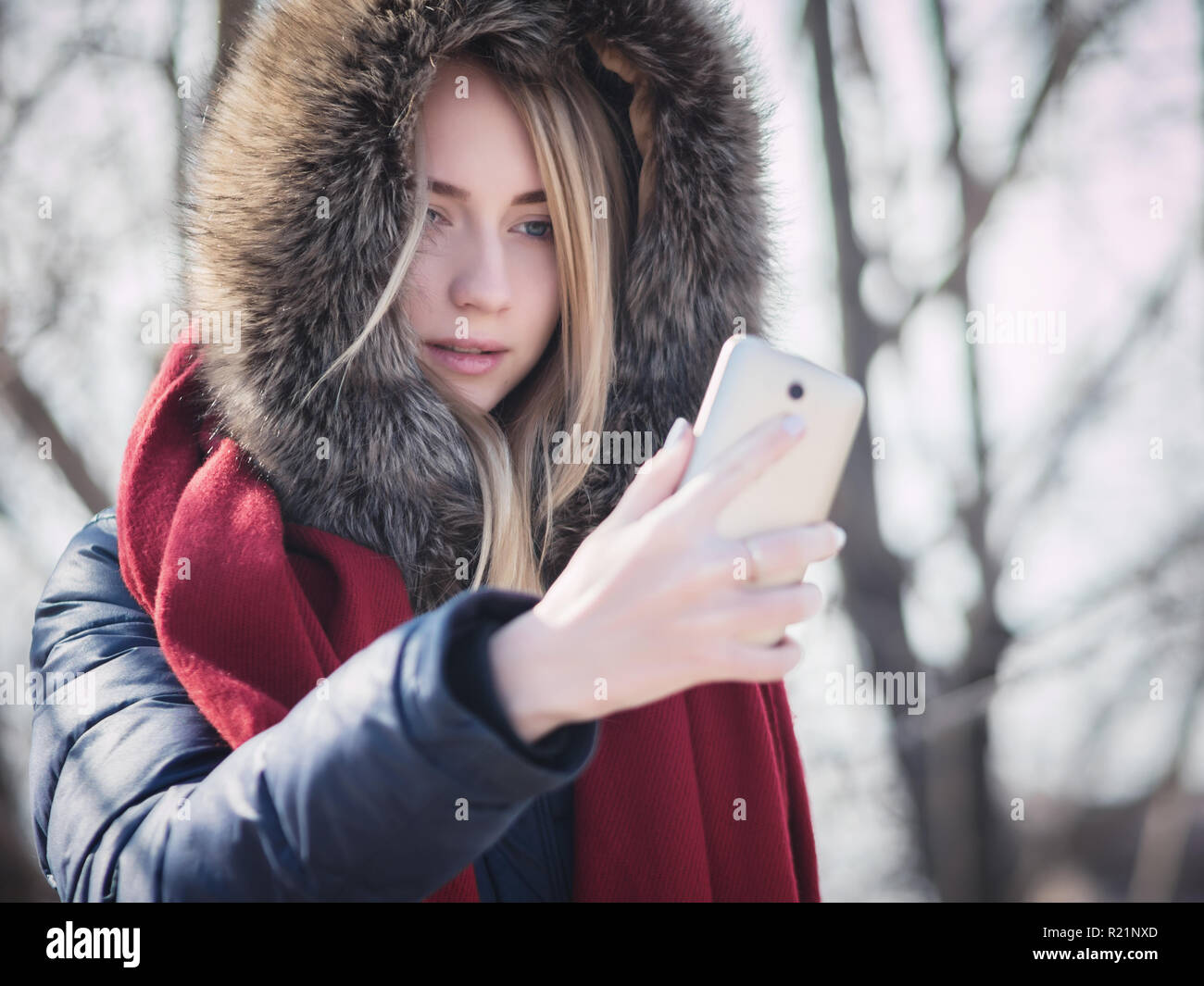 Giovane ragazza tenendo un selfie all'esterno. Foto Stock