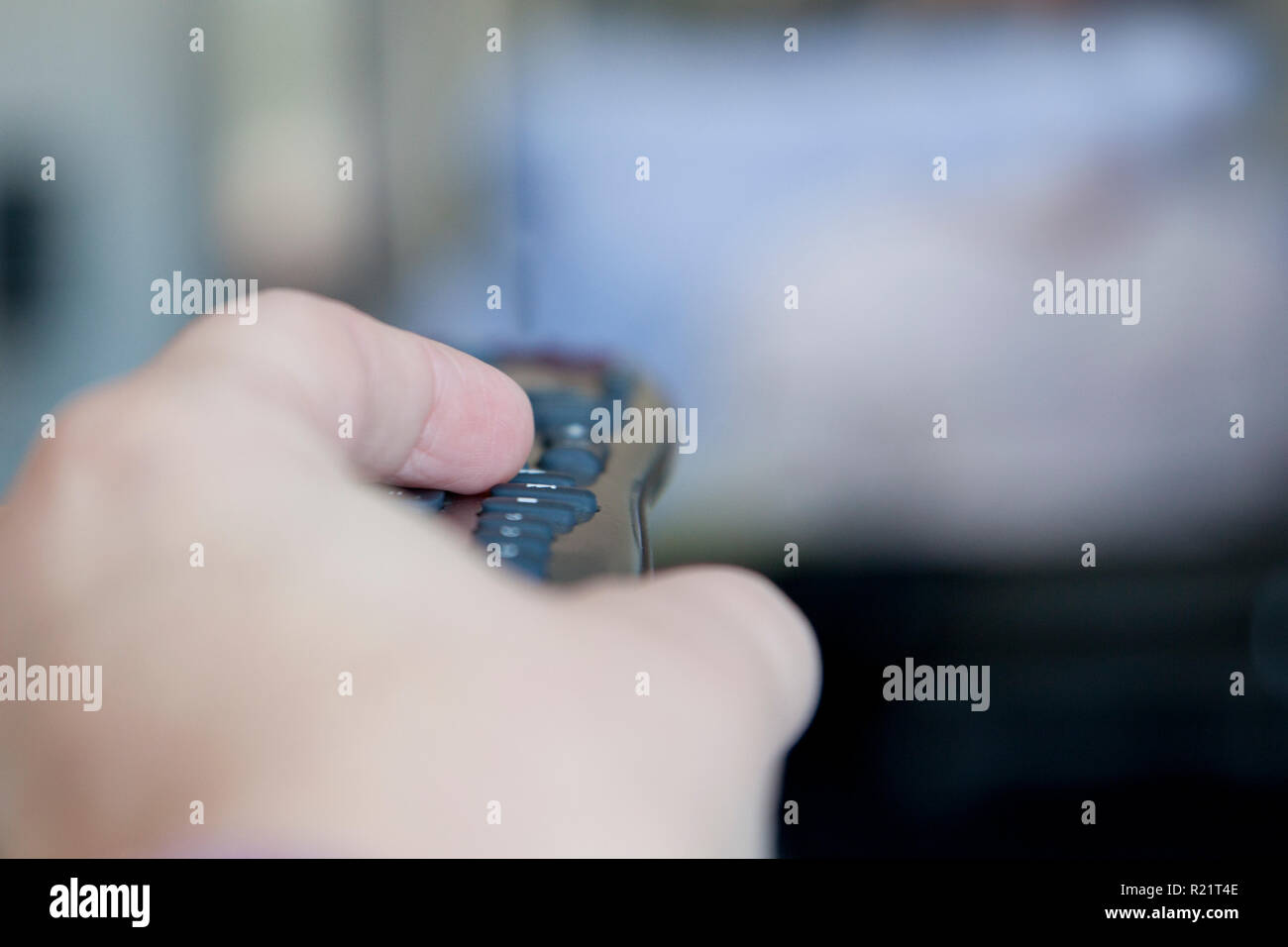 Mano puntare il telecomando verso il televisore Foto Stock