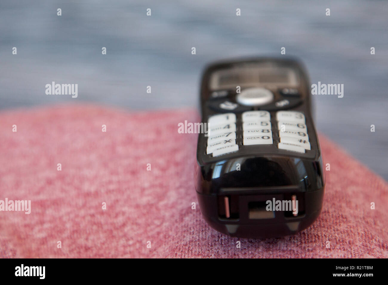 Un telefono cordless nero si siede in attesa di essere prelevato o composto Foto Stock