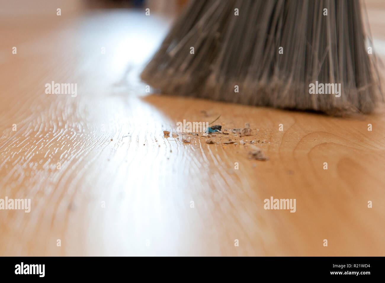 In prossimità di depositi di sporcizia e spazzato sul pavimento accanto a una scopa Foto Stock