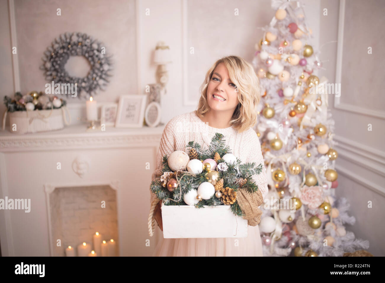 Giovane bella donna bionda decora l'albero di Natale giocattoli. Natale e Anno nuovo concetto. Foto Stock