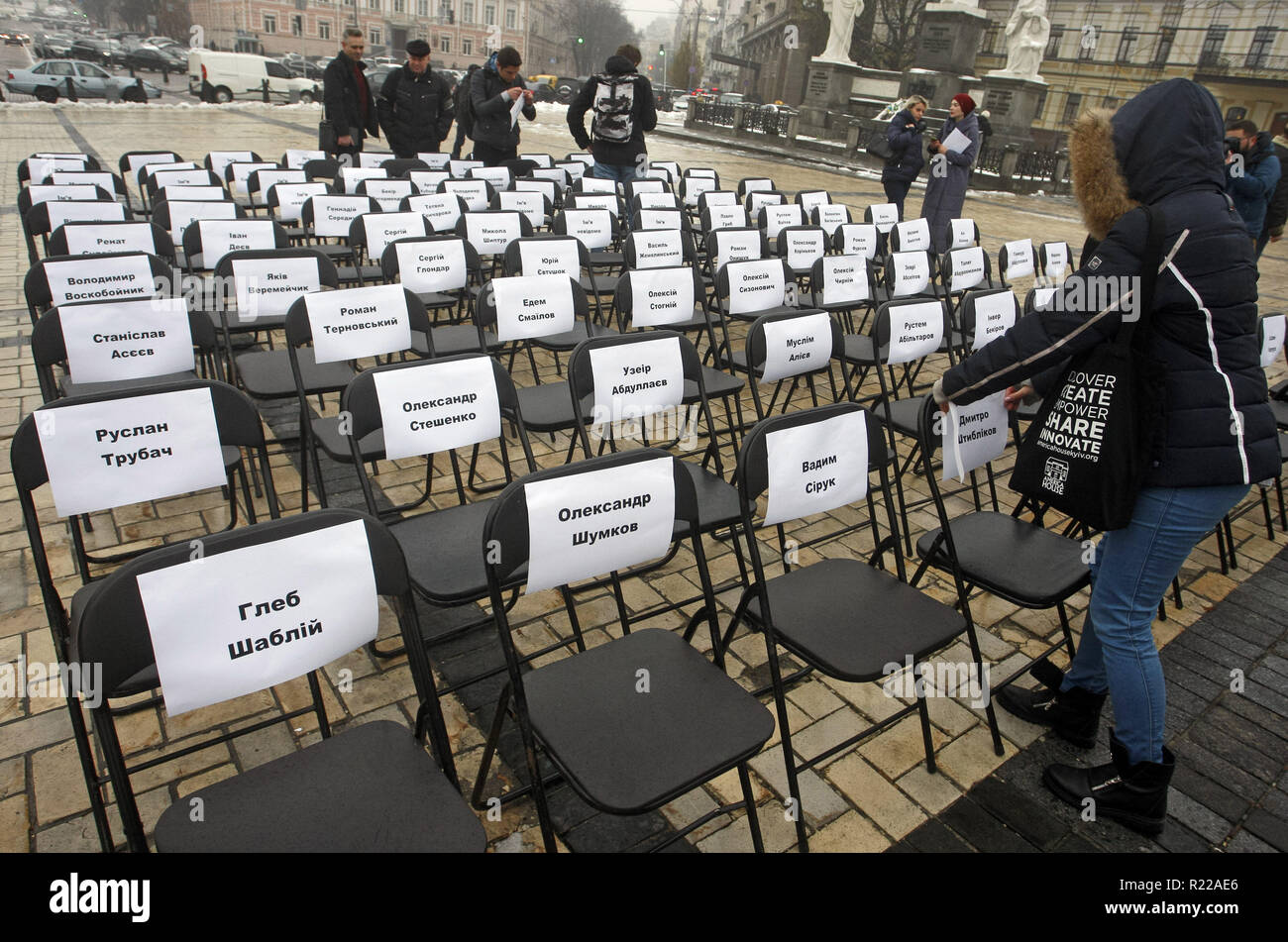 Kiev, Ucraina. Xv Nov, 2018. Gli attivisti ucraini allegare fogli con i nomi di ucraini di prigionieri politici in Russia per sedie, durante le prestazioni simbolico chiamato ''free sedie sulla San Michele Square a Kiev in Ucraina, il 15 novembre 2018. Il rally volti a sostenere il regista Oleg Sentsov e ucraino altri prigionieri politici in Russia, in Crimea e la zona di conflitto dell'est di ucraino. Una sedia vuota simboleggia un autore che non può essere presente su un particolare evento in un risultato di reclusione, detenzione, sparizione, un pericolo per la vita o di omicidio. (Credito Immagine: © Serg Gl Foto Stock