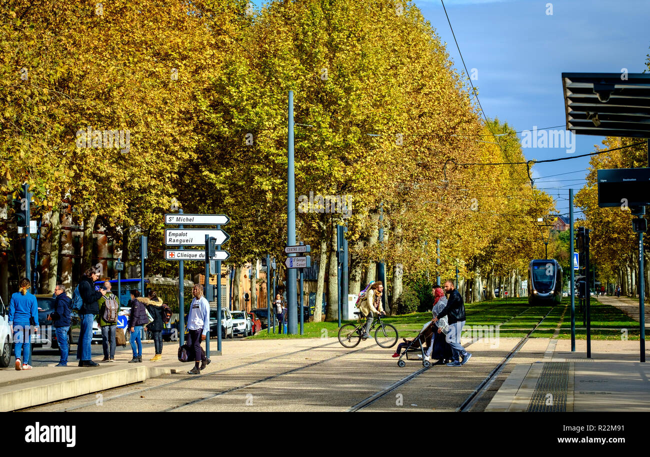 Pedoni che attraversano le linee di tram presso il Palais de Justice, Toulouse, Francia Foto Stock