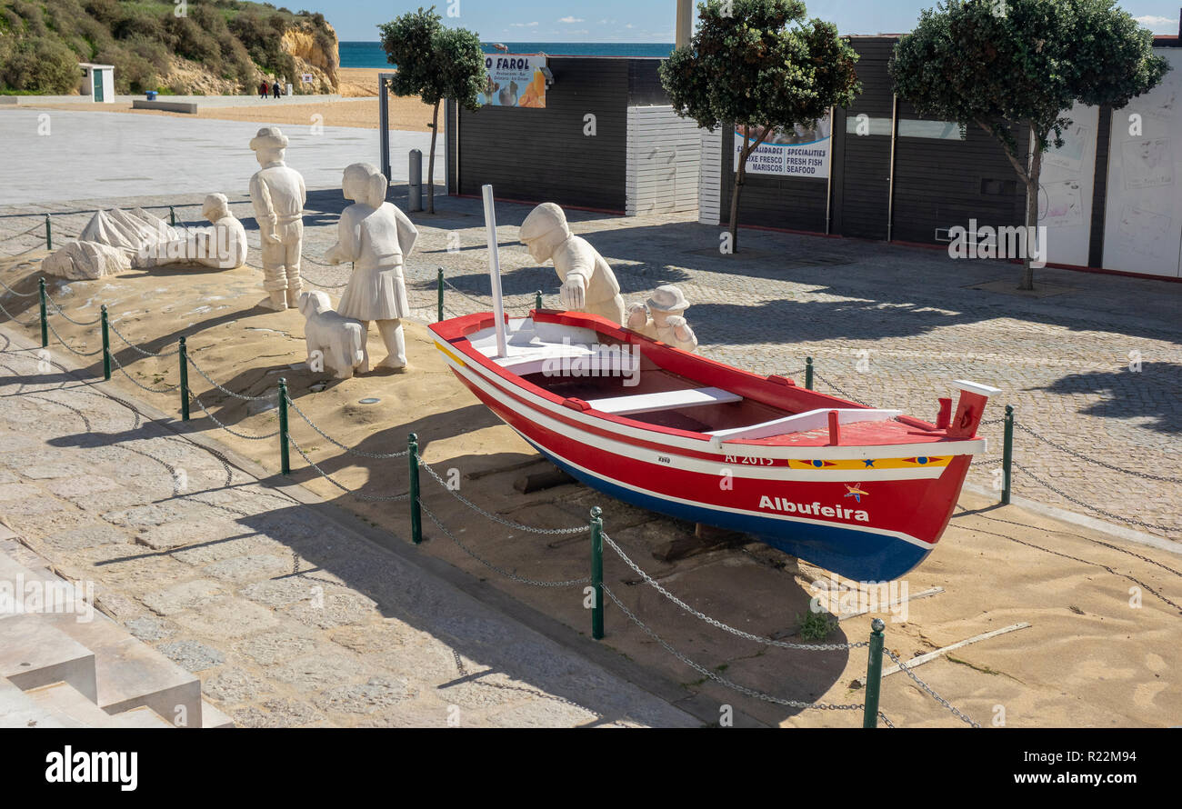 Un display di scultura di sabbia nelle figure e una tradizionale barca da pesca nel centro storico di Albufeira a Fishermans Beach, Praia dos isole Pescadores Foto Stock