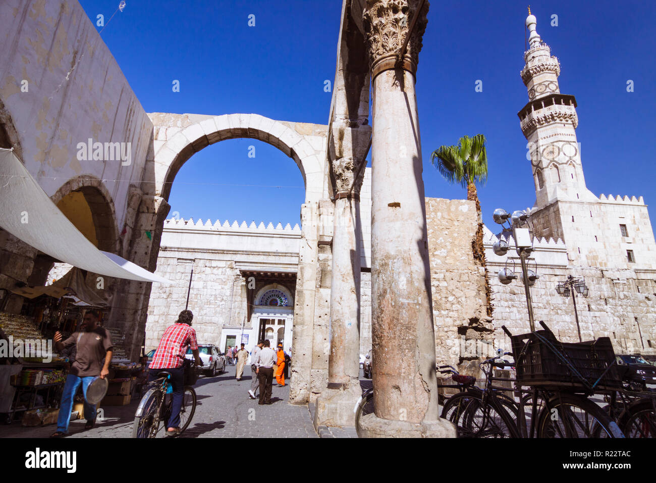 Damasco, Siria : la gente a piedi sotto i resti del romano Tempio di Giove presso l'entrata di Al-Hamidiyah Souq, costruito tra il I secolo A.C. e Foto Stock