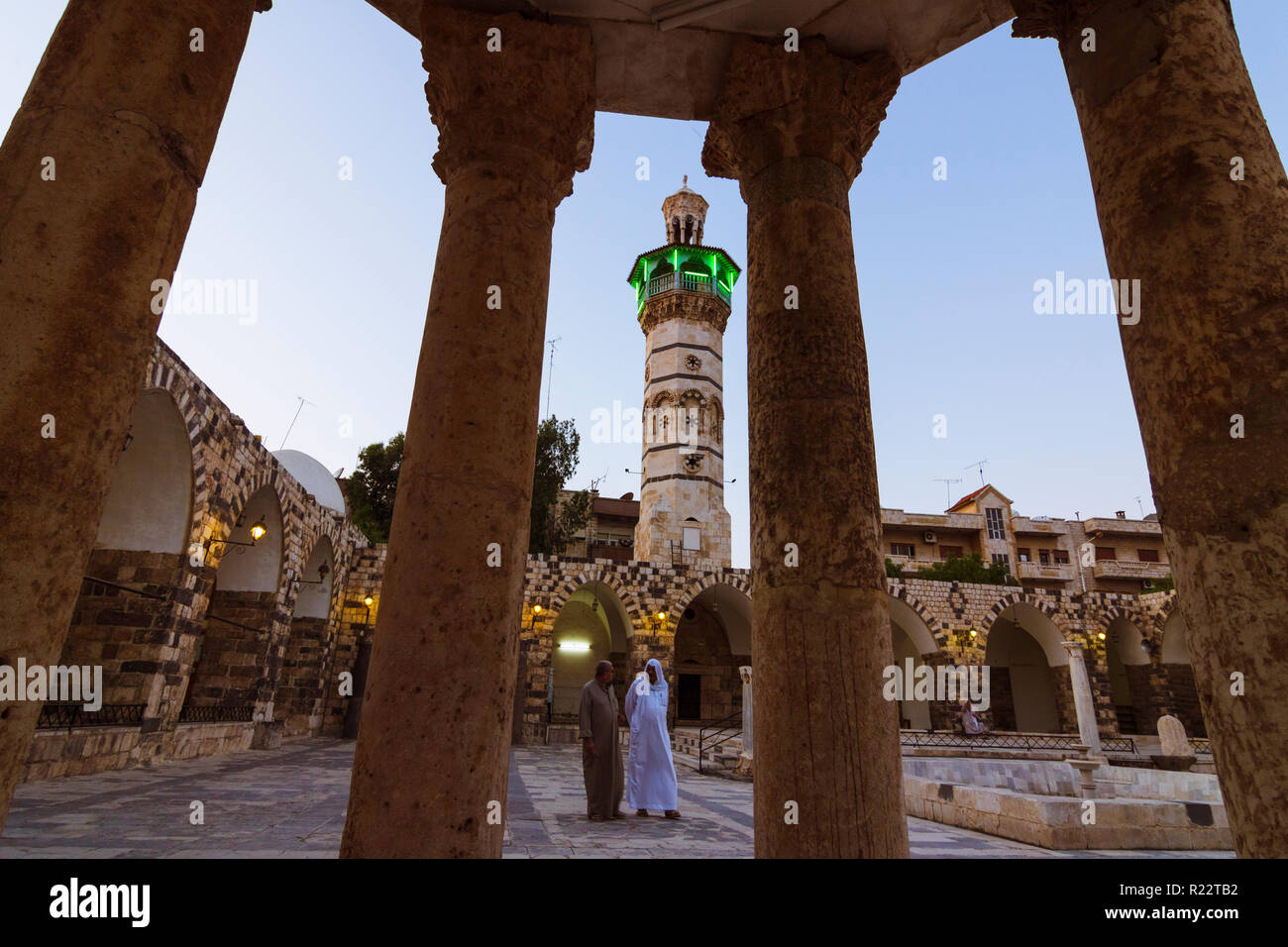 Hama, Governatorato di Hama, Siria : Due uomini a piedi passato la tesoreria elevati sul cortile del VIII secolo CE grande moschea di Hama. Foto Stock