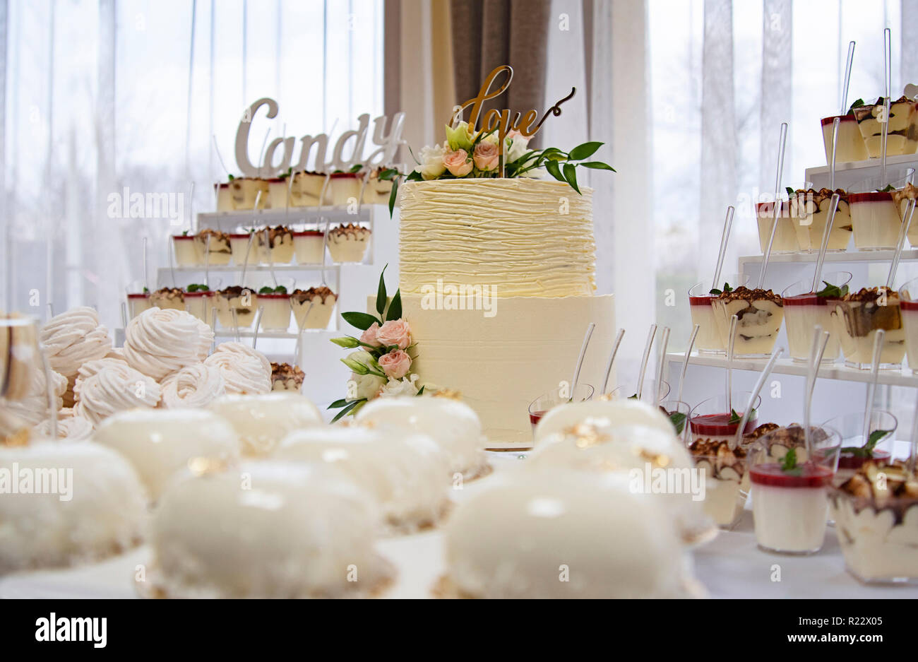 Candy bar. Torta di Nozze decorato da fiori in piedi di festosa tavola con deserti Foto Stock