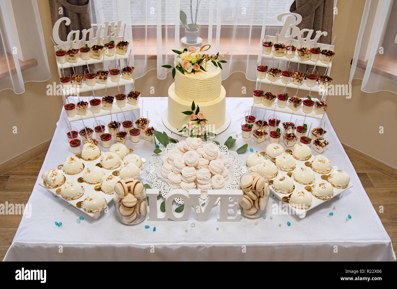 Candy bar. Torta di Nozze decorato da fiori in piedi di festosa tavola con deserti Foto Stock