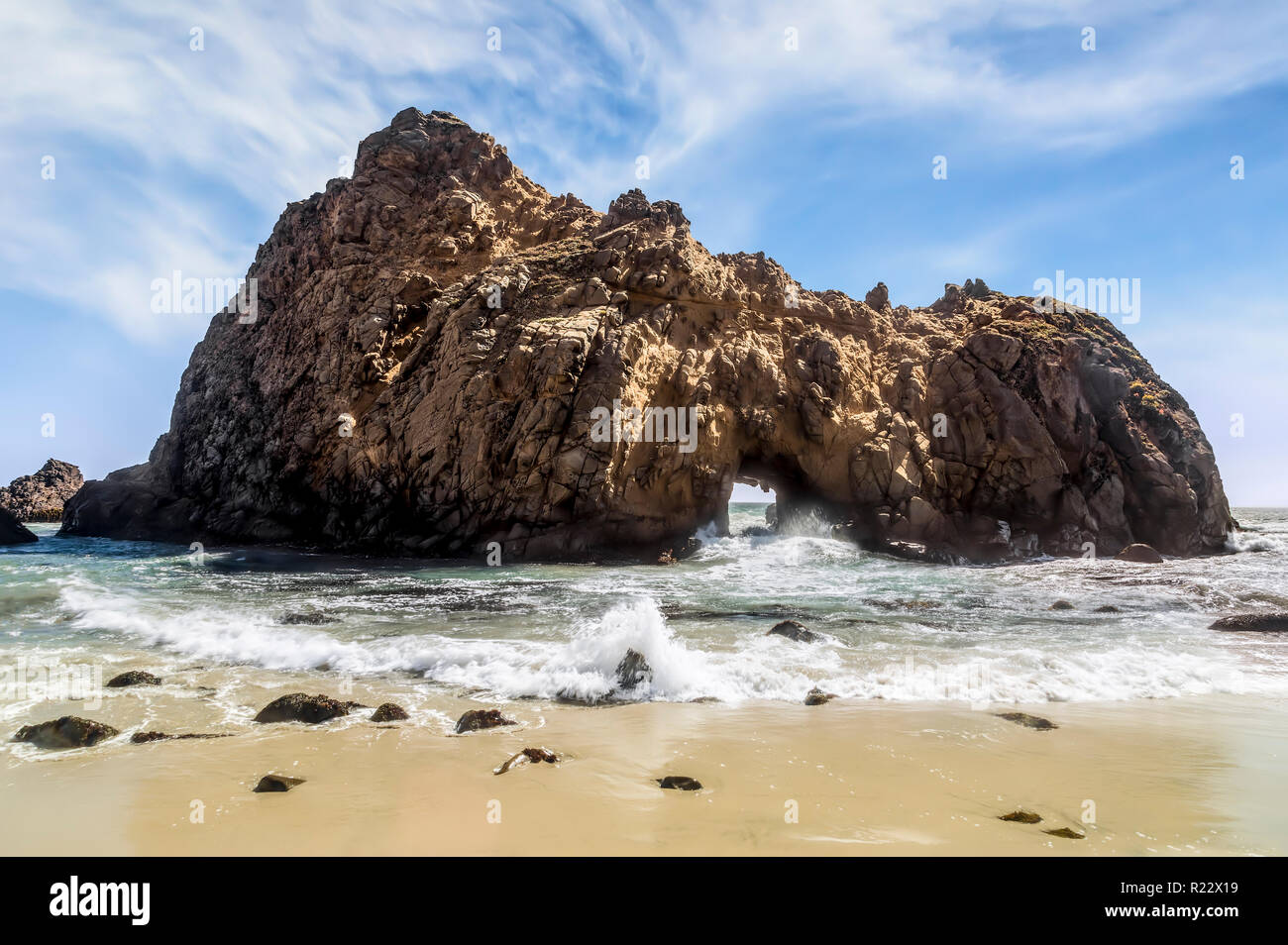 Pacific Ocean Waves splash attraverso il buco della serratura di tipo iconico Arch a Pfeiffer spiaggia lungo il Big Sur Costa della California. Foto Stock