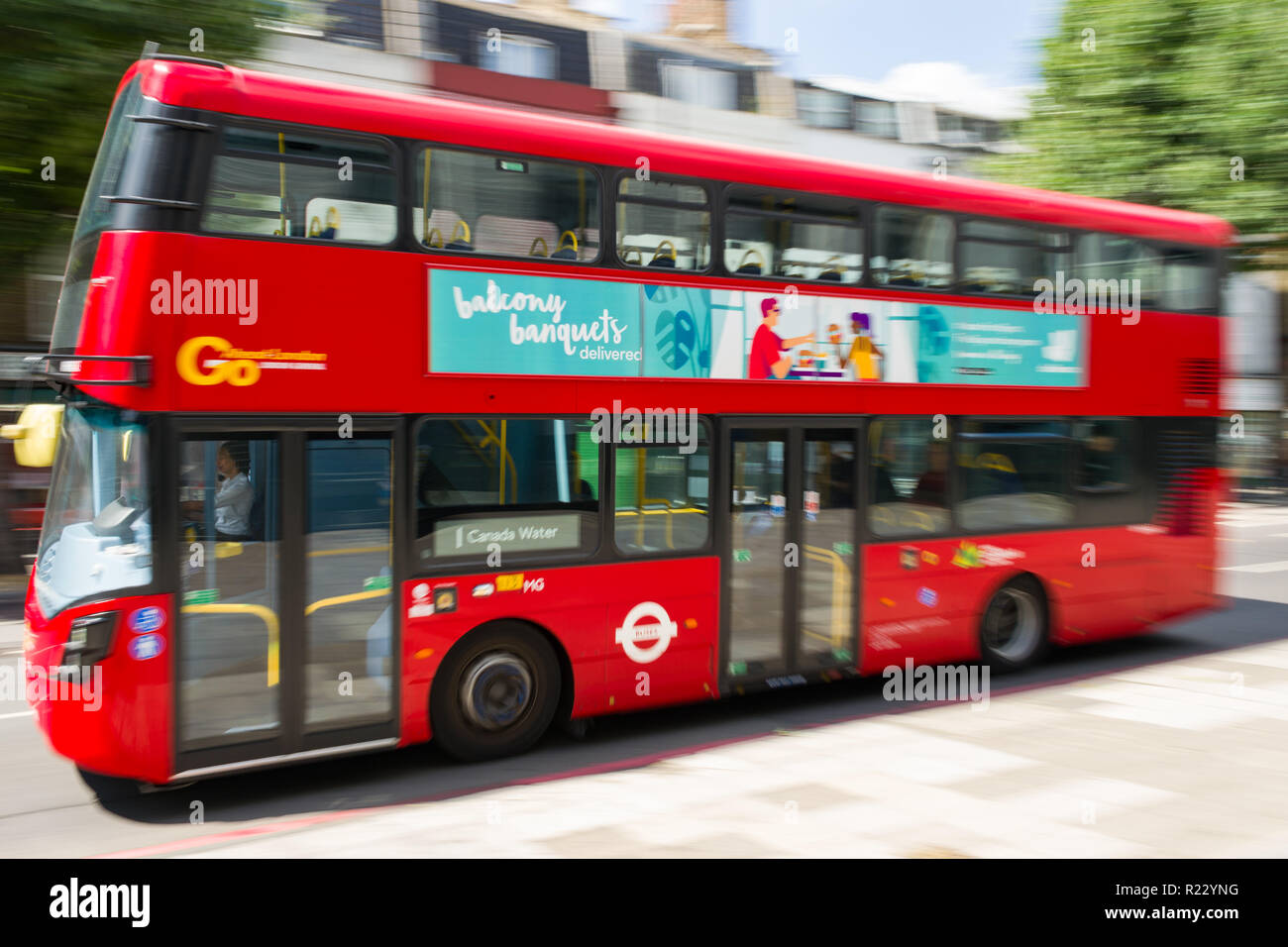Immagine panoramica di un bus rosso a due piani che si sposta lungo una strada a Londra in una giornata di sole, London, Regno Unito Foto Stock
