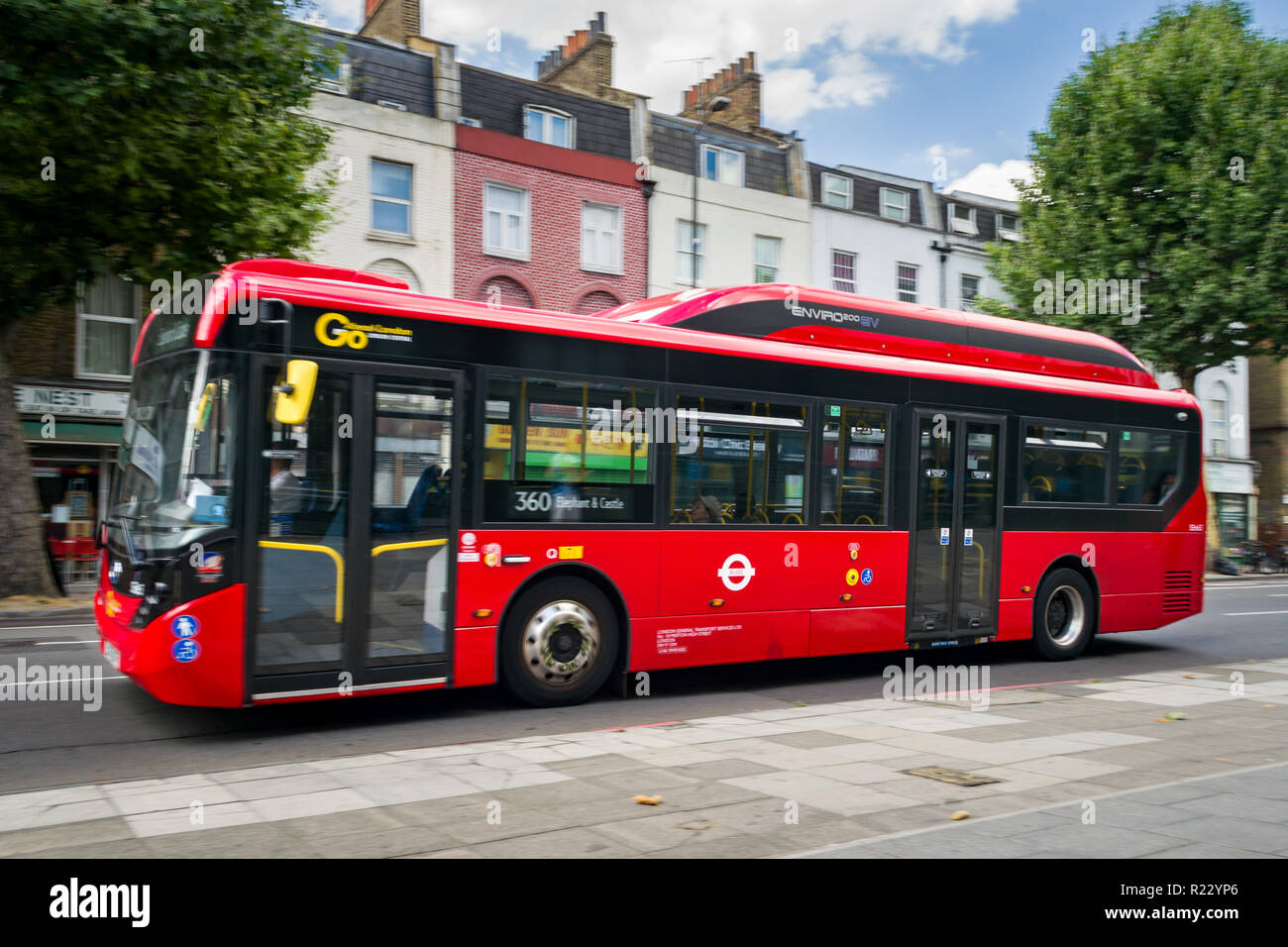 Immagine panoramica di un Enviro 200 EV bus rosso come si percorre una strada a Londra, Regno Unito Foto Stock