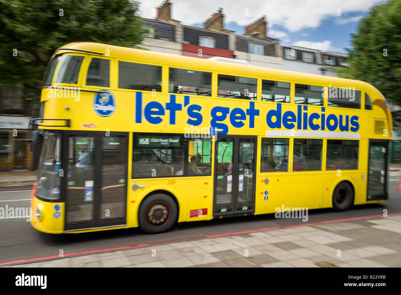 Immagine panoramica di un giallo double decker bus con banane Chiquita Mettiamoci Delizioso su di esso come si percorre una strada a Londra, Regno Unito Foto Stock