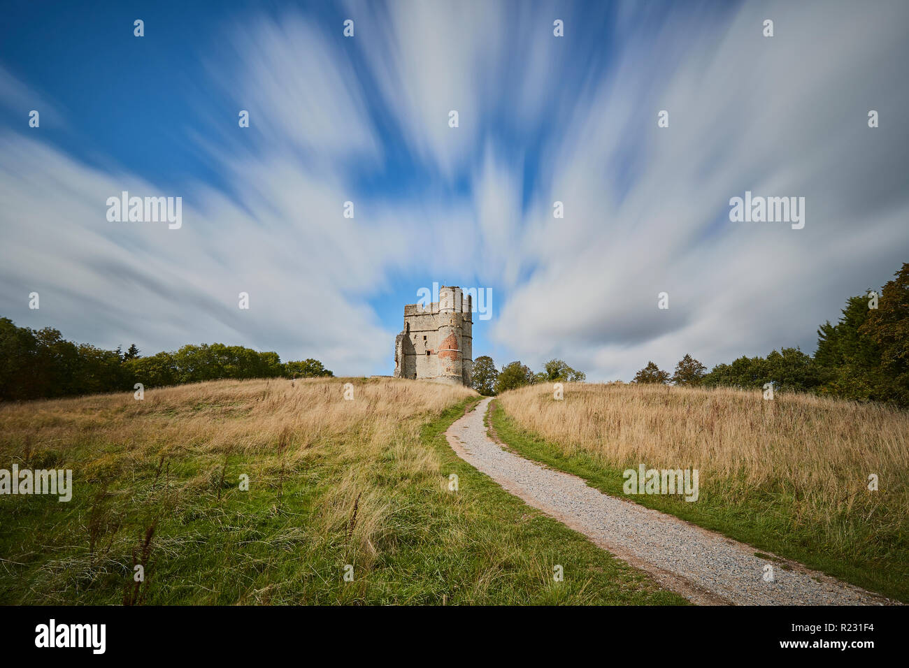 Castello di Donnington con nuvole bianche striature sopra la parte superiore con un percorso che conduce ad esso su una giornata d'estate, Newbury, Berkshire, Regno Unito Foto Stock