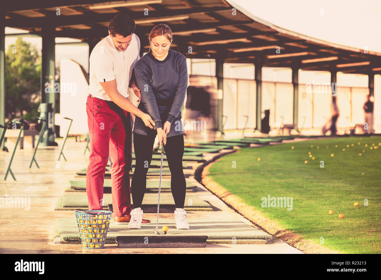 Uomo felice golf trainer donna che mostra il giocatore come colpire giustamente a sfera Foto Stock