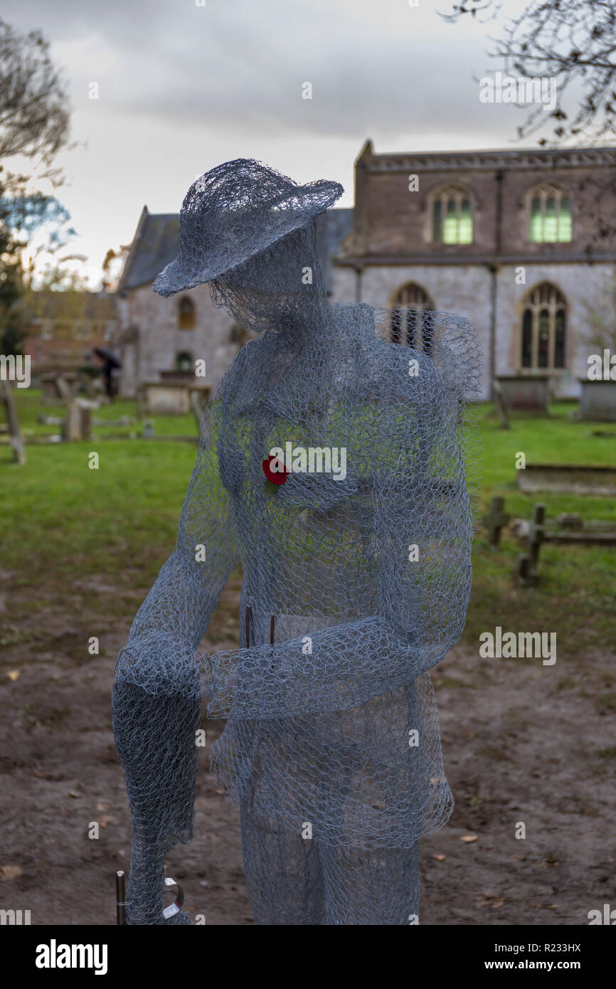 "Ghostlike' sculture (dall artista Jackie Lantelli) di soldati morti nella guerra mondiale uno accanto alle loro tombe nel cimitero di Slimbridge Foto Stock