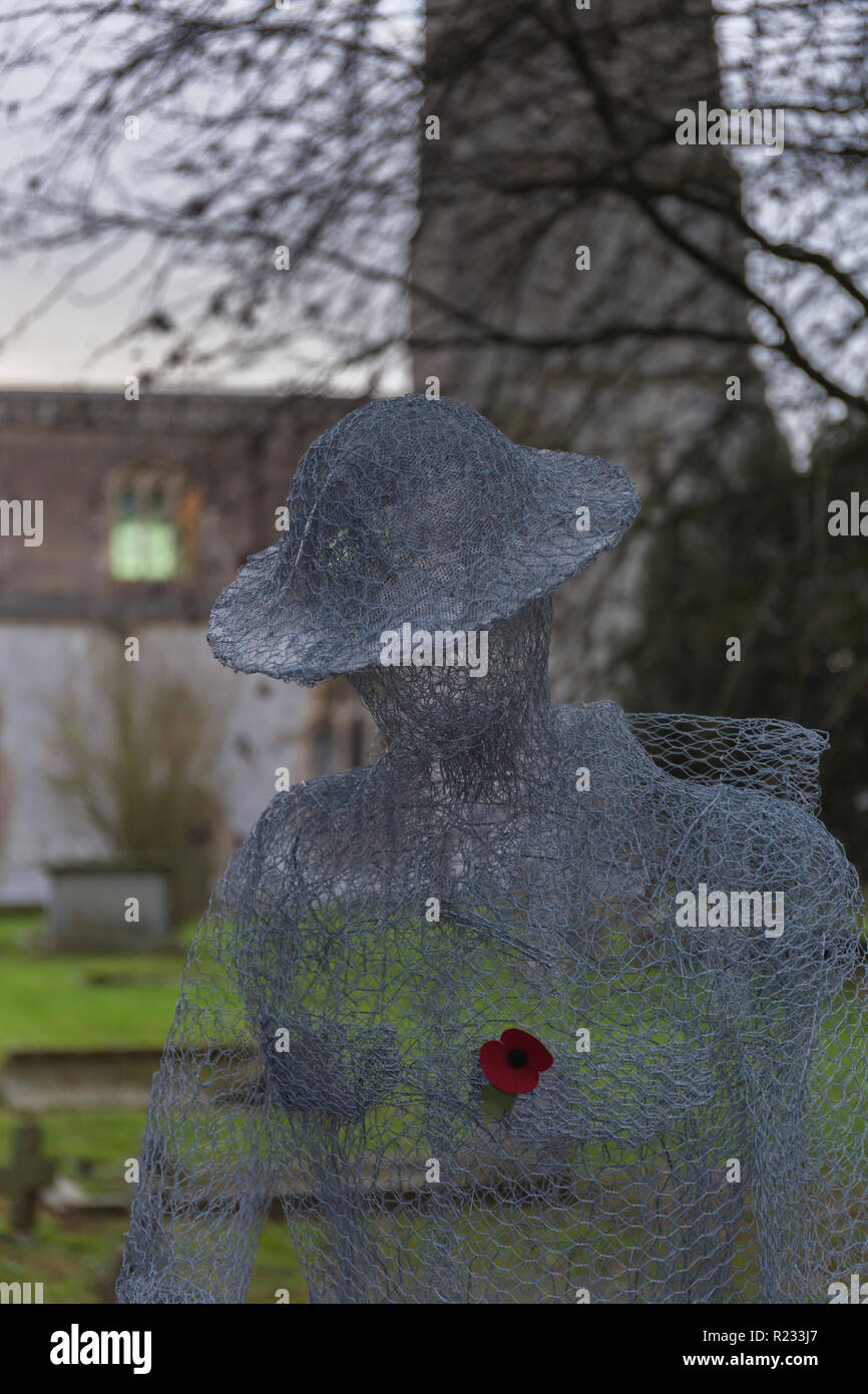 "Ghostlike' sculture (dall artista Jackie Lantelli) di soldati morti nella guerra mondiale uno accanto alle loro tombe nel cimitero di Slimbridge Foto Stock