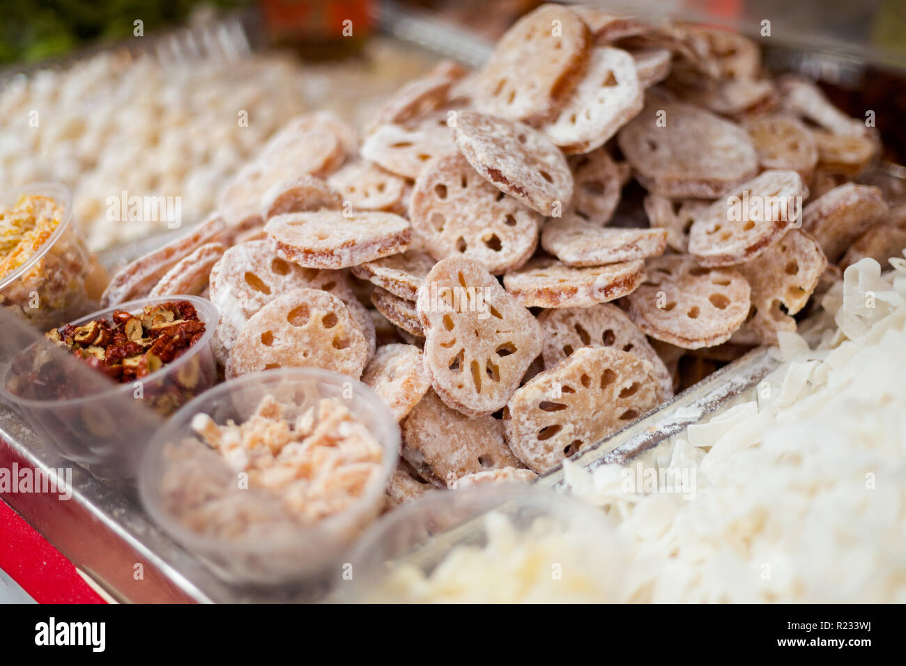 Anno Nuovo Cinese specialty essiccato lotus fette rivestite di zucchero. Street food dolci sulla Cina città in Singapore. Foto Stock