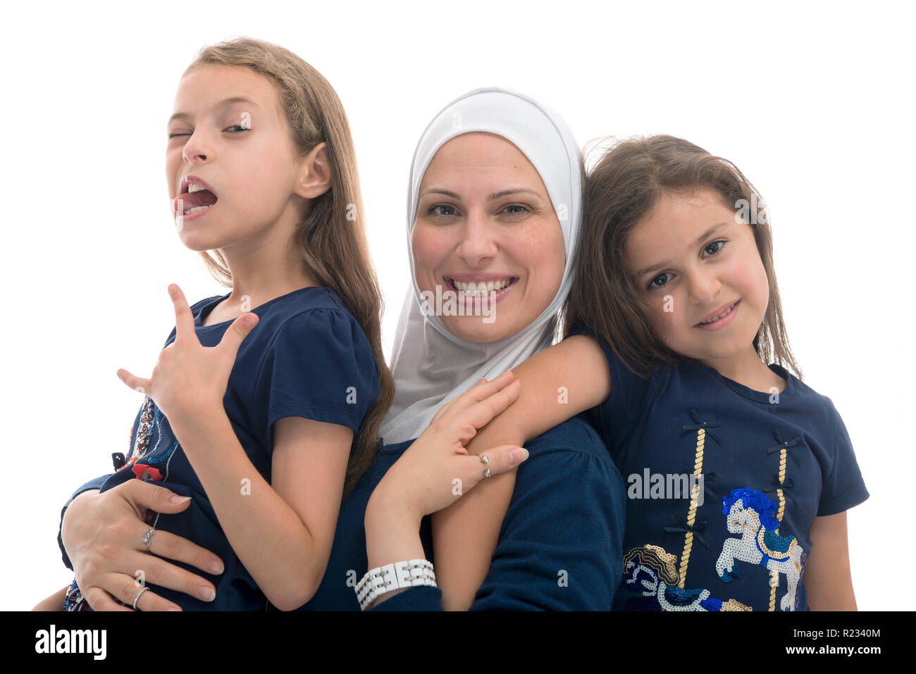 Felice musulmano famiglia femmina, sua madre e la sua divertente pongono le figlie isolati su sfondo bianco Foto Stock