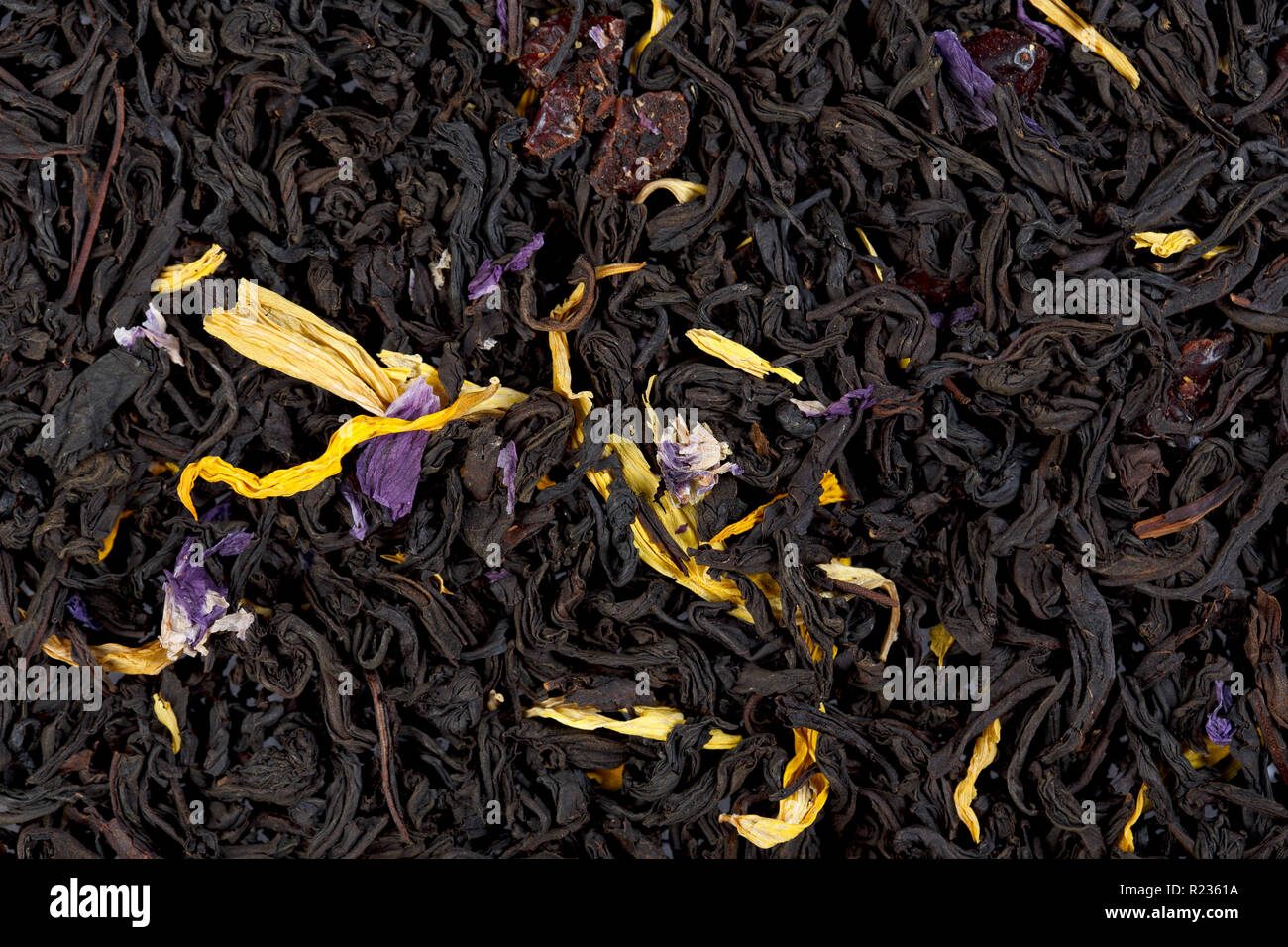 Nero aromatico foglie di tè con semi di girasole e petali di fiordaliso Foto Stock