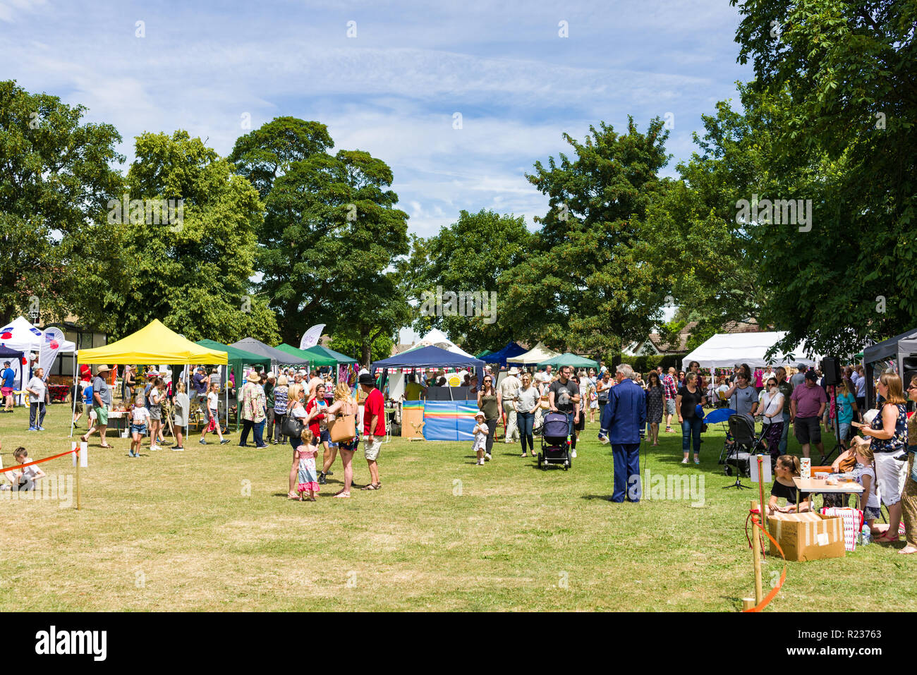 Una folla di persone ad un'estate fete in un campo su una soleggiata giornata estiva, Brampton, REGNO UNITO Foto Stock