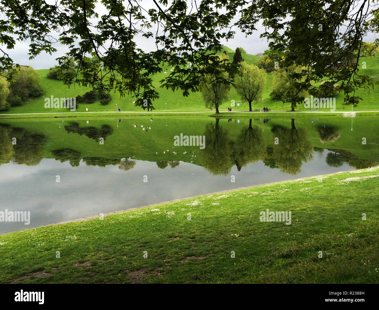 Lago con riflessioni, Olympiapark, Monaco di Baviera, Germania Foto Stock