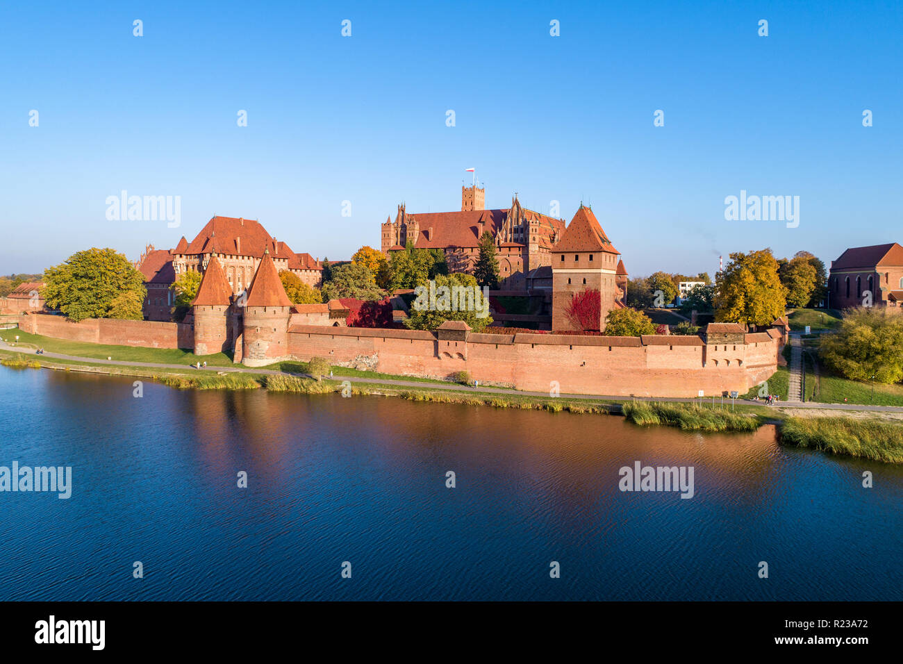 Medieval Malbork (Marienburg) castello in Polonia, fortezza principale dei Cavalieri Teutonici presso il fiume di Nogat. Vista aerea in caduta nella luce del tramonto. Foto Stock