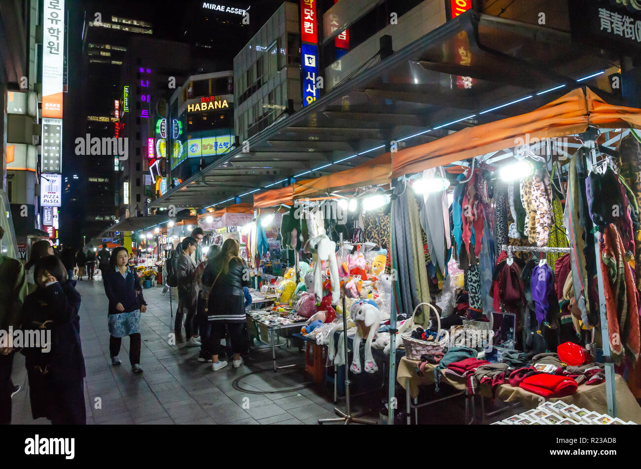 Ai clienti di sfogliare le bancarelle del mercato a un mercato di strada a Seul, in Corea del Sud di notte. Foto Stock