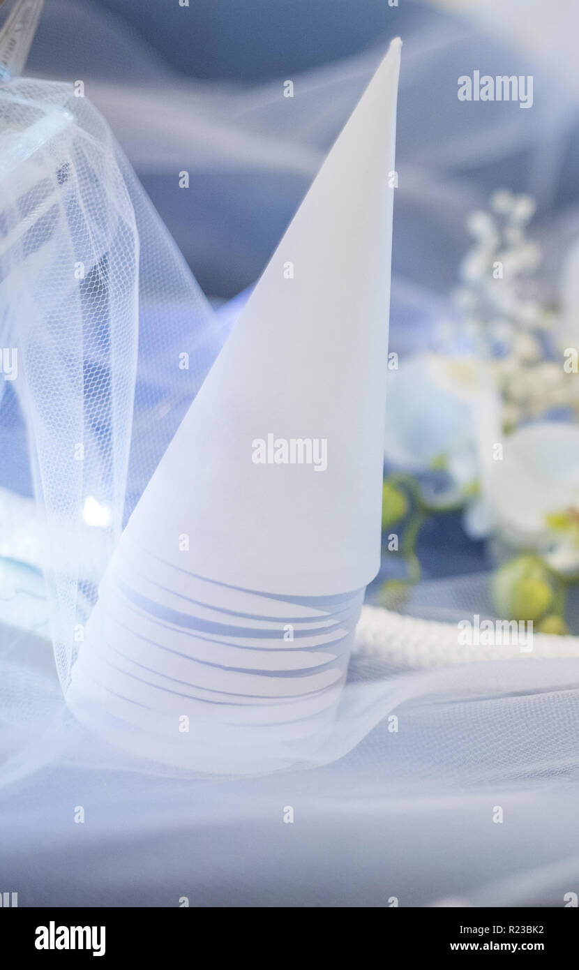 Cono di bianco per confetti sul tavolo blu decorato per cerimonia, immagine pronta per personalizzare con il vostro testo su cono Foto Stock
