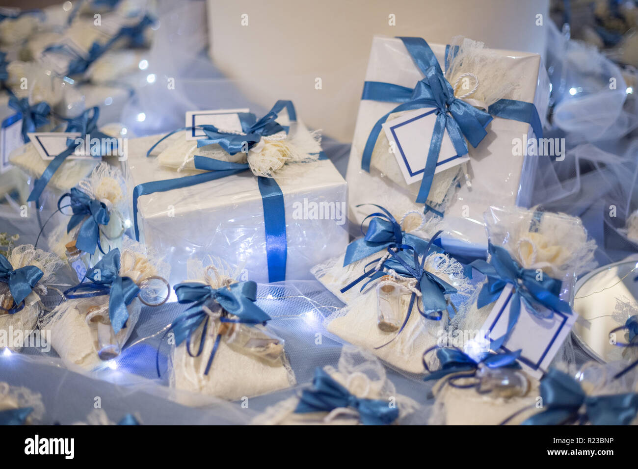 Bomboniera decorata con pizzo e nastro di colore blu con un messaggio in bottiglia con etichette bianche pronti a personalizzare con il vostro testo Foto Stock