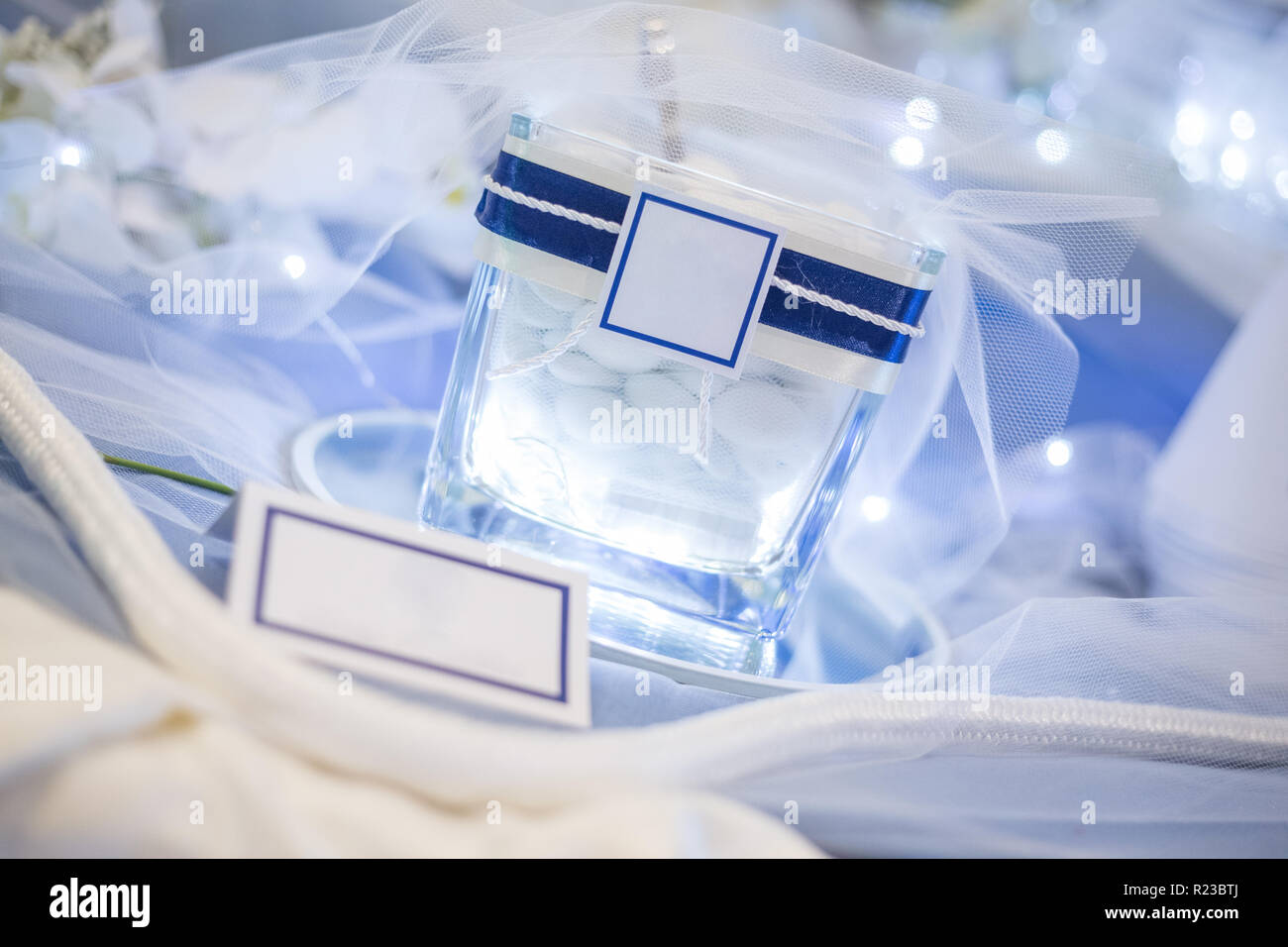 Vaso illuminato con i confetti con white label per personalizzare l'immagine, la corda per la decorazione e il cono per confetti sul tavolo blu. Foto Stock