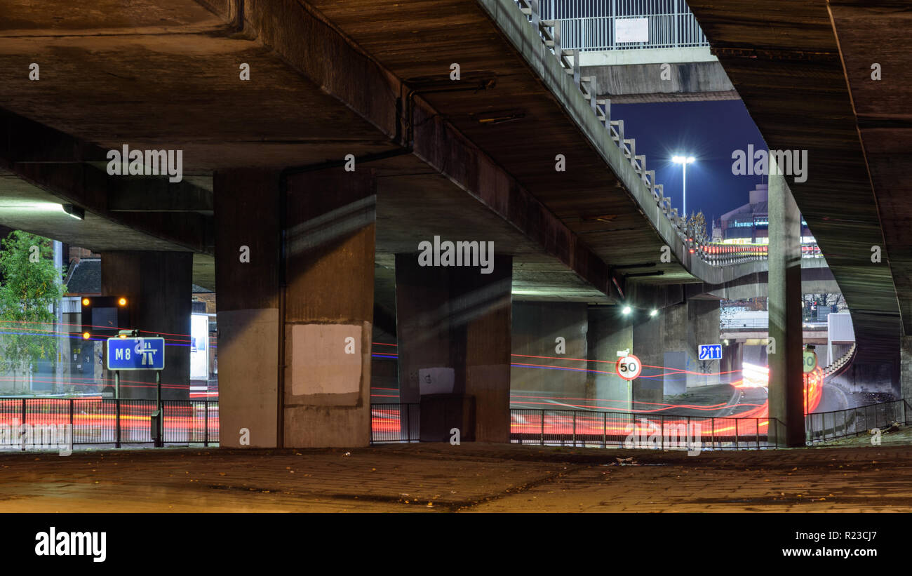 Glasgow, Scotland, Regno Unito - 6 Novembre 2018: il traffico lascia sentieri di luce tra un groviglio di calcestruzzo flyover e scivolo strade all' autostrada M8 Ander Foto Stock
