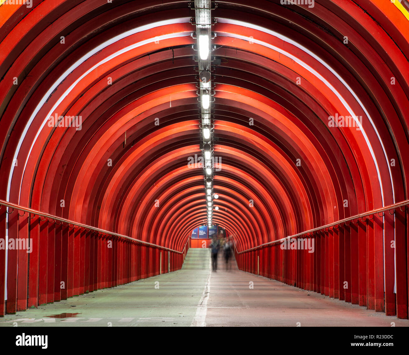Glasgow, Scotland, Regno Unito - 4 Novembre 2018: pedoni a piedi attraverso un colore rosso brillante passaggio coperto che collega l'evento scozzese Campus al centro esposizioni Foto Stock