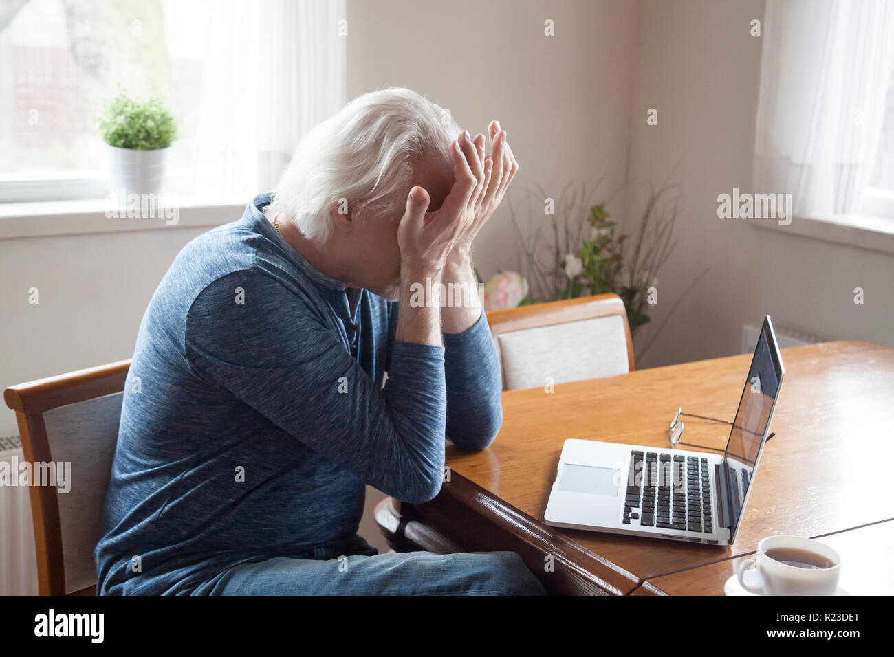 Stanco di età compresa tra uomo agli occhi di massaggio funziona troppo a lungo al computer portatile, maschio senior sentirsi sfiniti soffrono di mal di testa dopo l uso dei computer, anziani avente sfocata Foto Stock