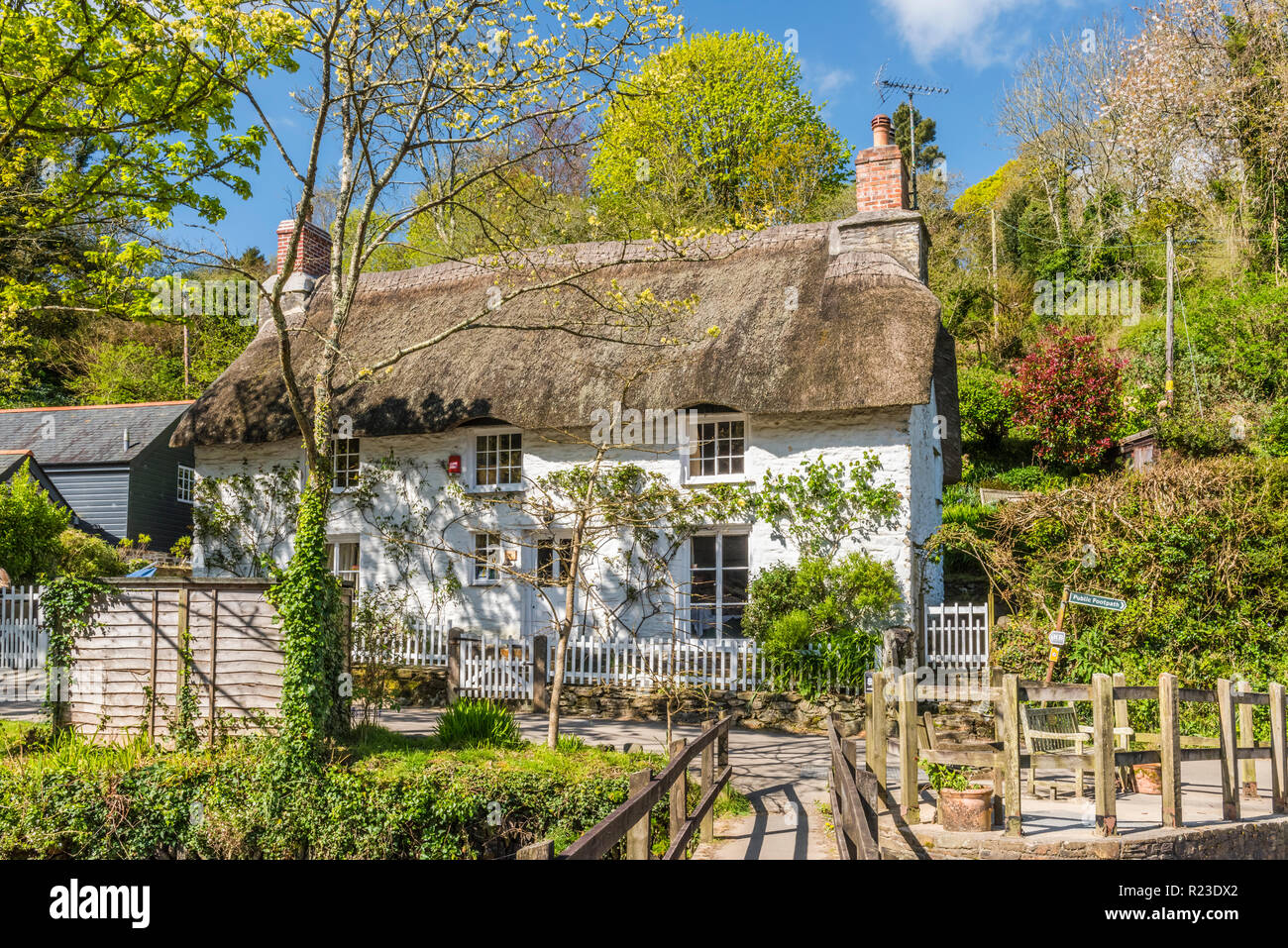 Un pittoresco cottage con tetto in paglia e passerella in Helford, Cornwall, Inghilterra Foto Stock