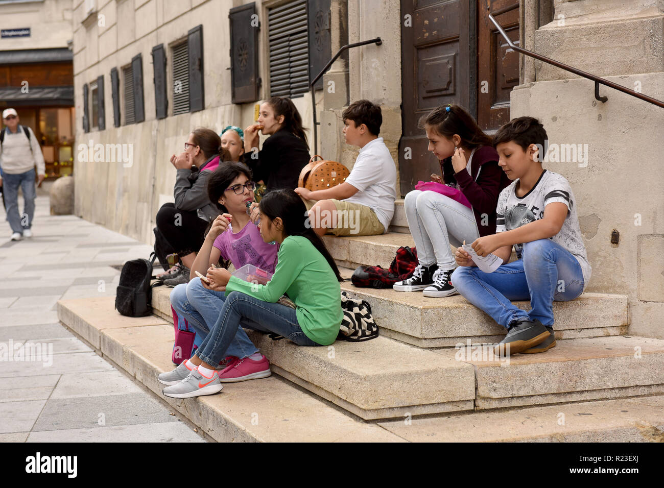 Vienna, Austria gruppo di bambini di scuola gli alunni di prendere una pausa pranzo in centro città Foto Stock