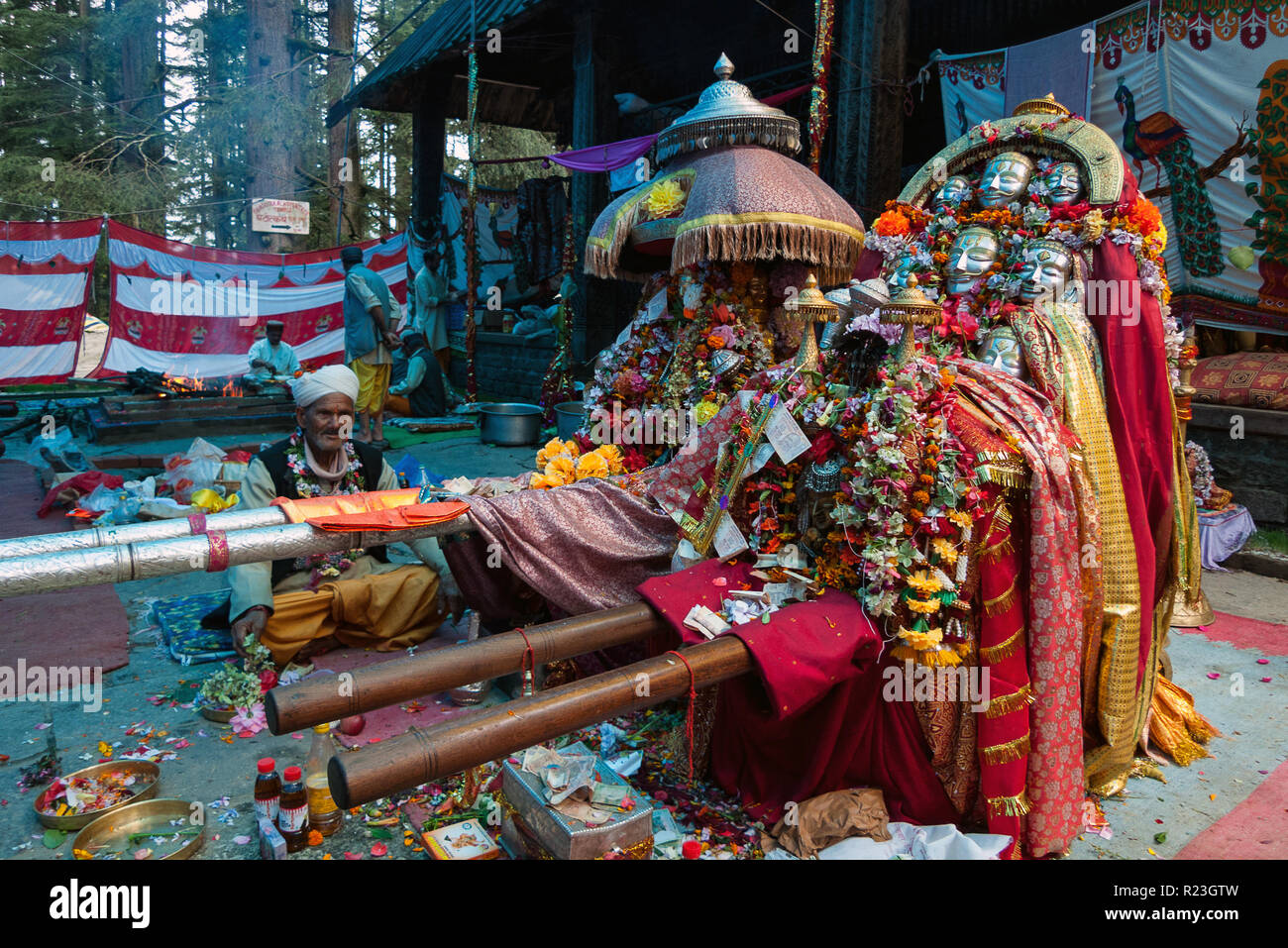 India, Himachal Pradesh, Manali, 08/08/2010: un sacerdote Indù si siede vicino le maschere e l'effigie della dea Hadimba presso il tempio di Hadimba in Manali Foto Stock