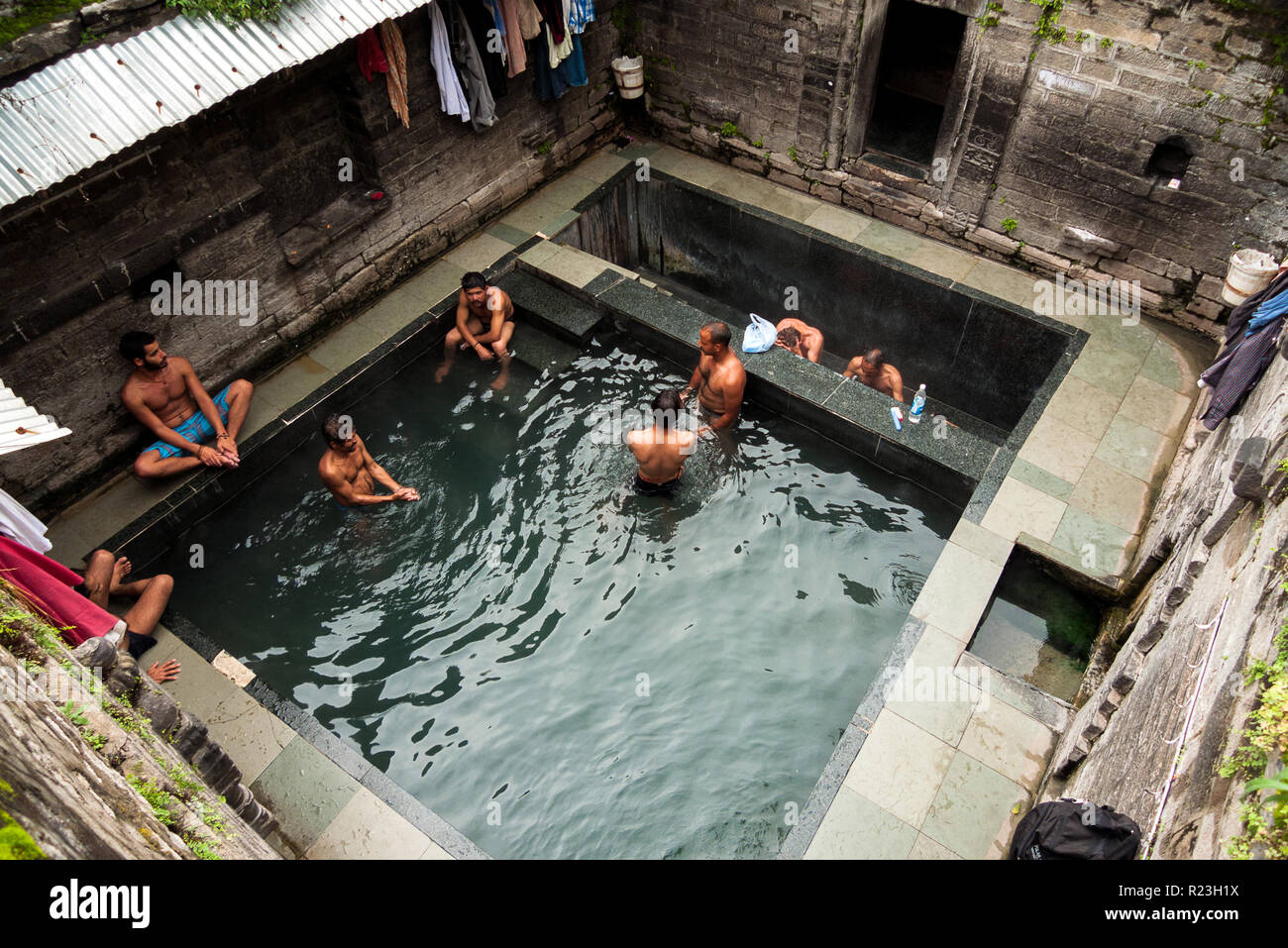 India, Himachal Pradesh, Vashisht, 08/11/2010: alcuni giovani uomini si bagnano nelle terme di Vashist Foto Stock