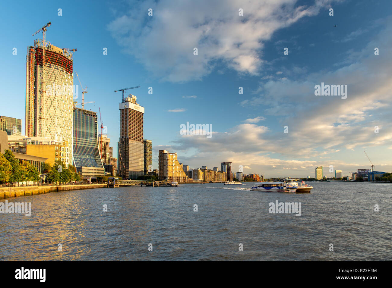 London, England, Regno Unito - 14 Settembre 2018: A Thames Clipper traghetto parte Canary Wharf pier sotto un cluster di nuovi grattacieli attualmente costruiti su Foto Stock