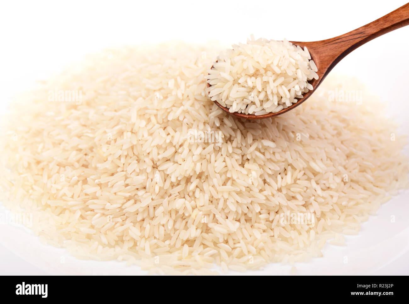 Cucchiaio di legno pieno di riso a grani lunghi. Concetto di generi alimentari. Close up Foto Stock