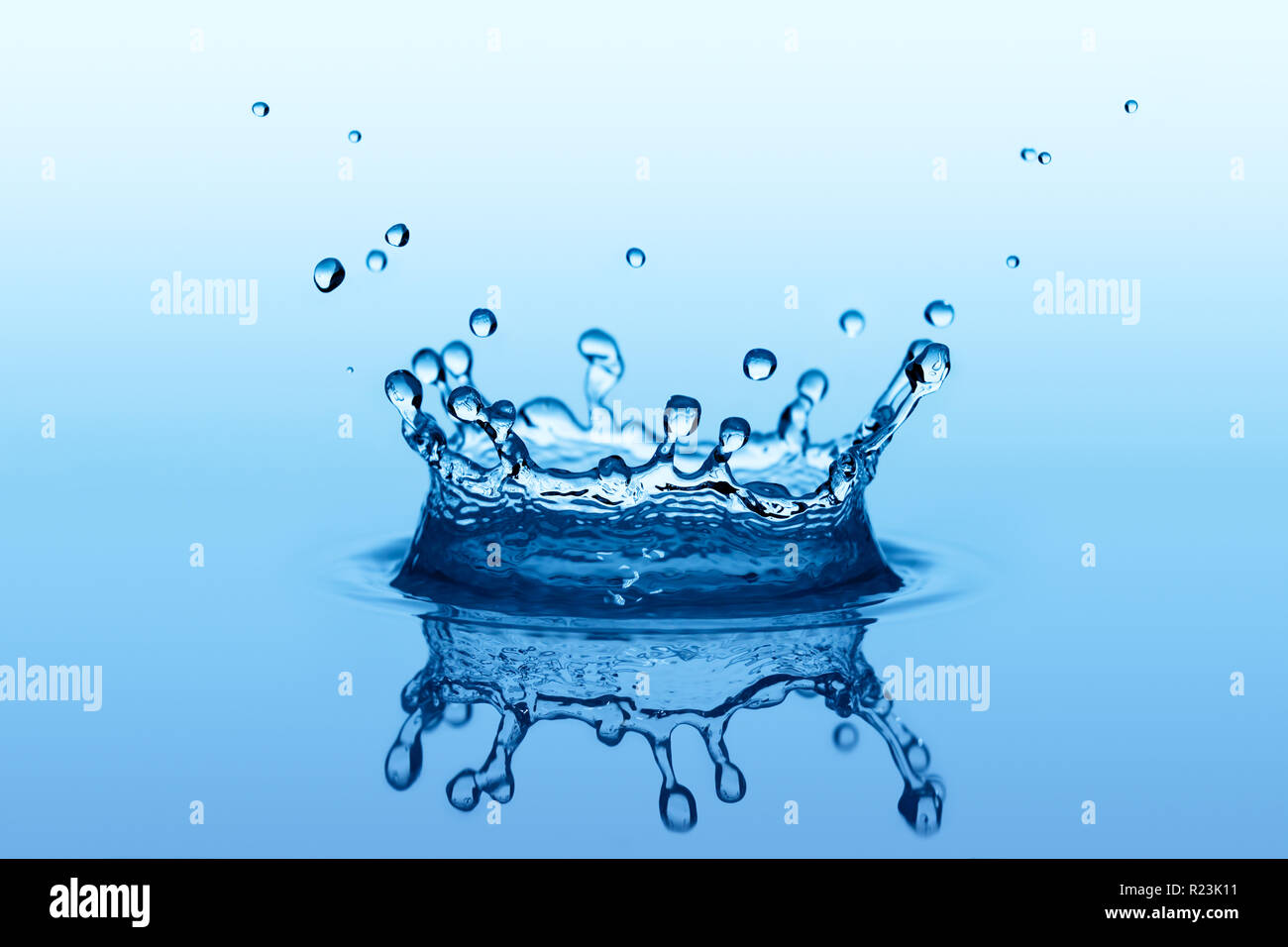 Blu schizzi di liquido in forma di corona con piccole gocce di acqua Foto Stock