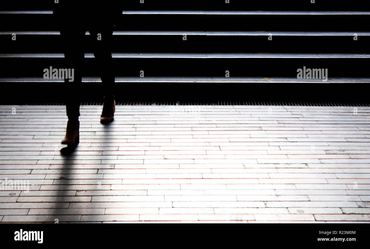 Persona che va in giù la città scura street scale, gambe in motion blur Foto Stock