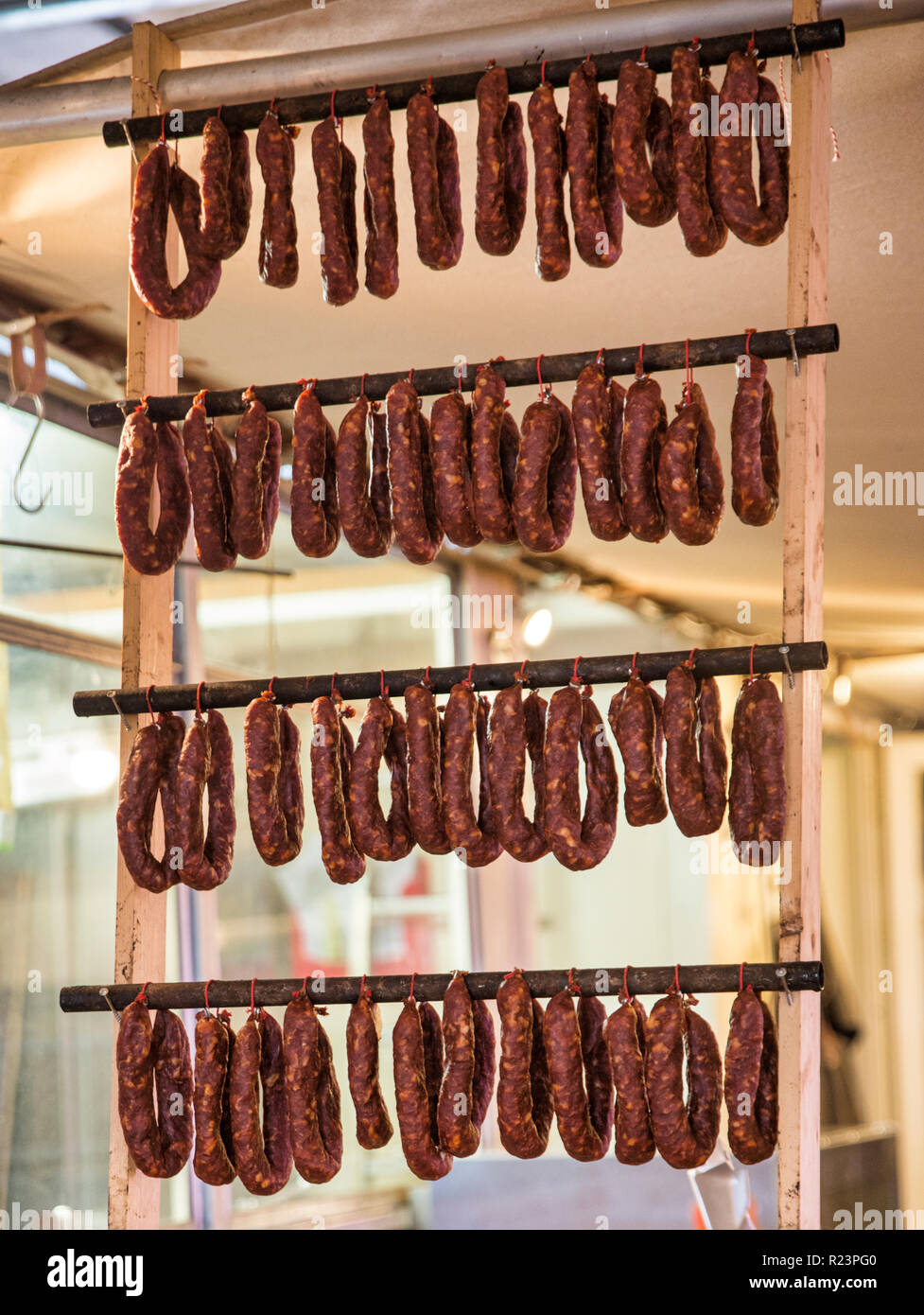 Righe di salami appesi ed essiccamento in negozio , pronti per la vendita Foto Stock