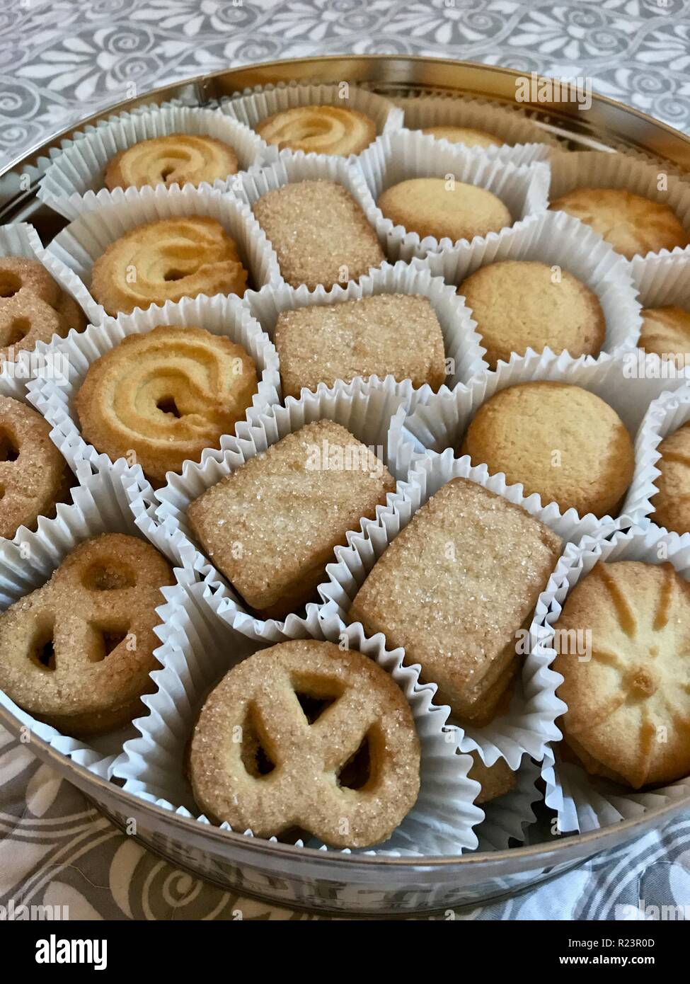 Imburrare i biscotti su una griglia da forno con una teiera e il latte  sullo sfondo Foto stock - Alamy