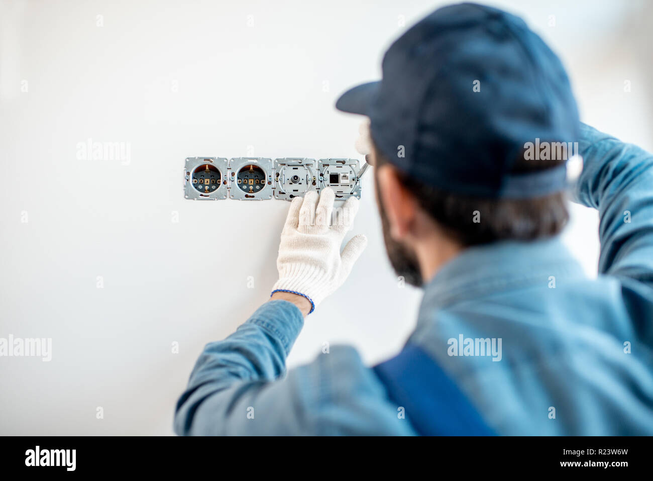 Elettricista tecnico al lavoro su una zona residenziale quadro elettrico,  per la misura della tensione con il tester Foto stock - Alamy