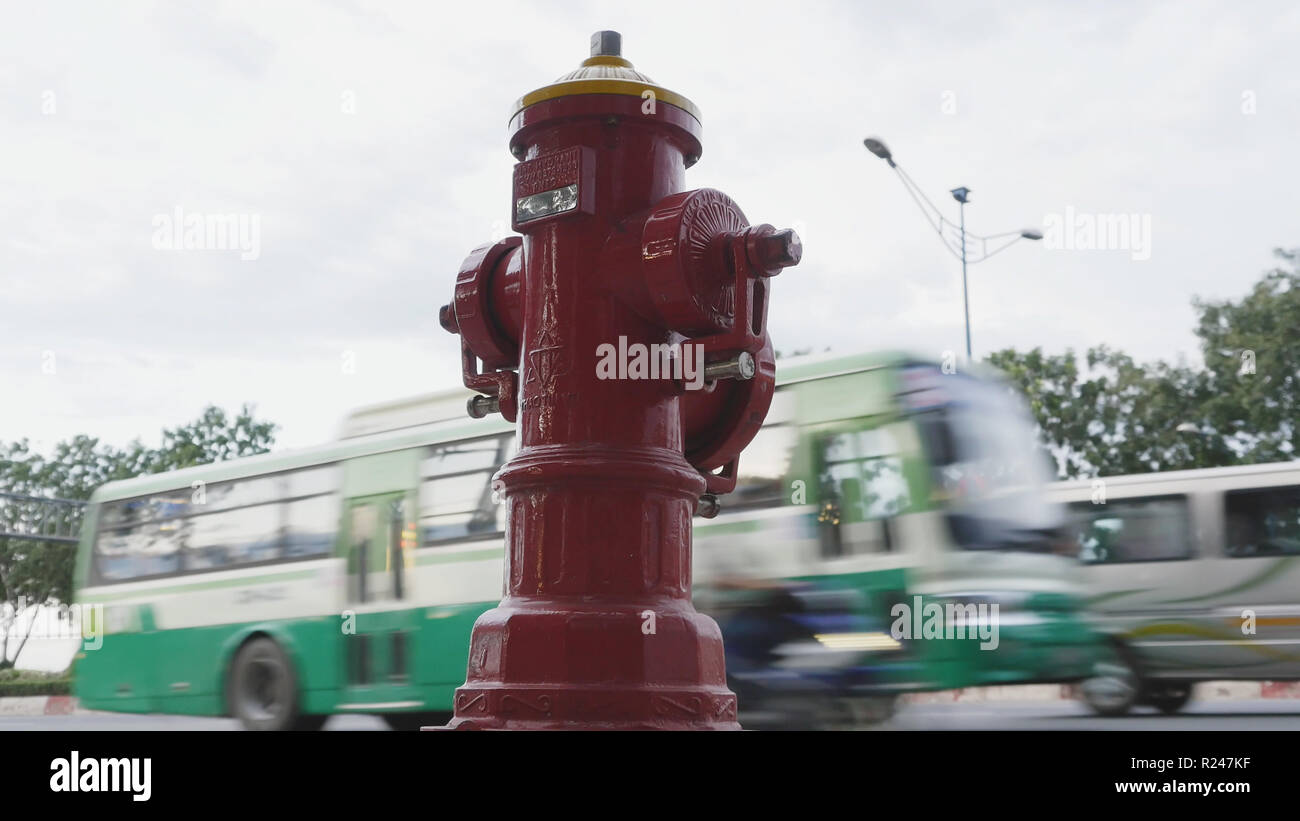Rosso fuoco idrante poli su street Ho Chi Minh city. Accanto alla strada e passaggio di automobili e motociclette. Il Vietnam. Foto Stock