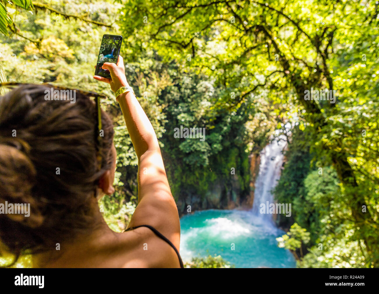 Un turista di scattare una foto del Rio Celeste a cascata in Tenorio Il Parco Nazionale del Vulcano, Costa Rica, America Centrale Foto Stock