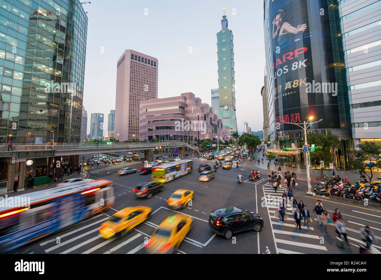 Il traffico nella parte anteriore del Taipei 101 in corrispondenza di un centro occupato intersezione nel distretto di Xinyi, Taipei, Taiwan, Asia Foto Stock