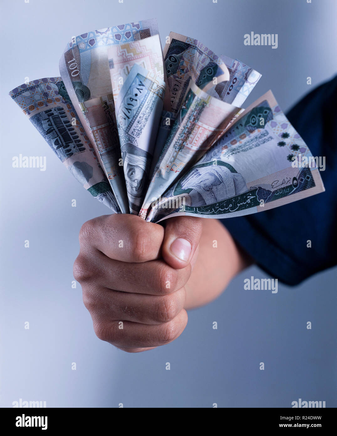Adulto mano che tiene un mazzetto di Saudi Riyal banconote di 500, 200 e 100 fatture Foto Stock